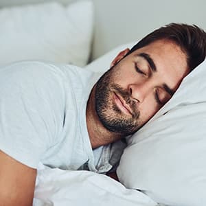 A sleeping man who is taking a sleep home test